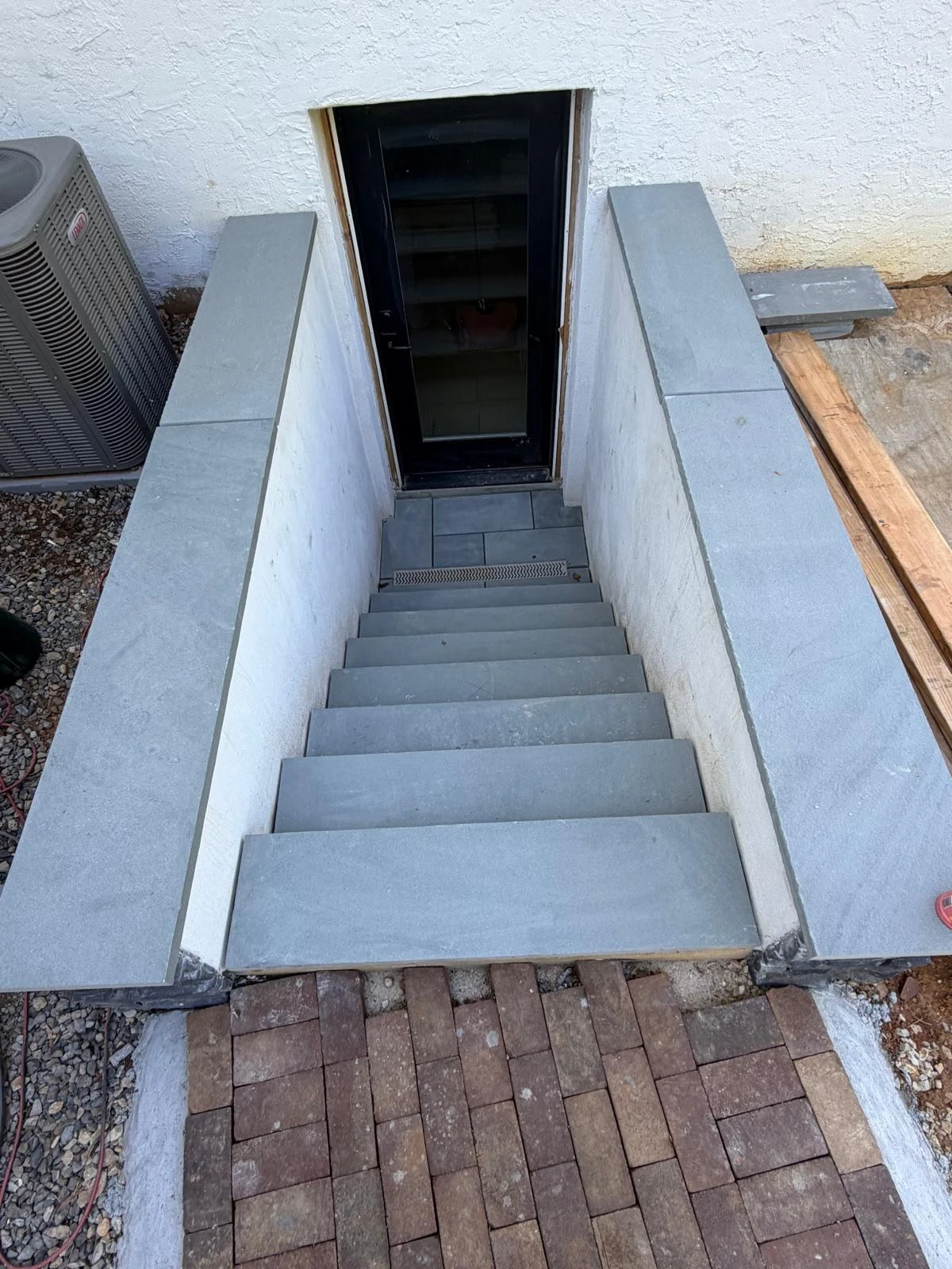 Below-grade entrance stairs and rendered side walls.